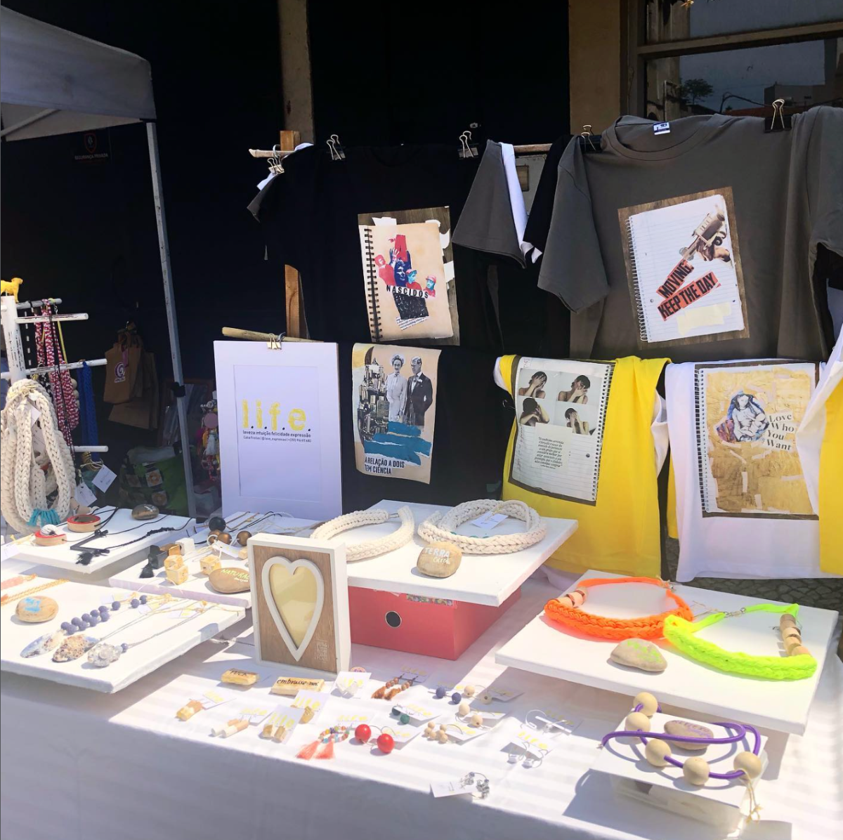 Banca de mercado com peças de bijuteria e t-shirts estampadas